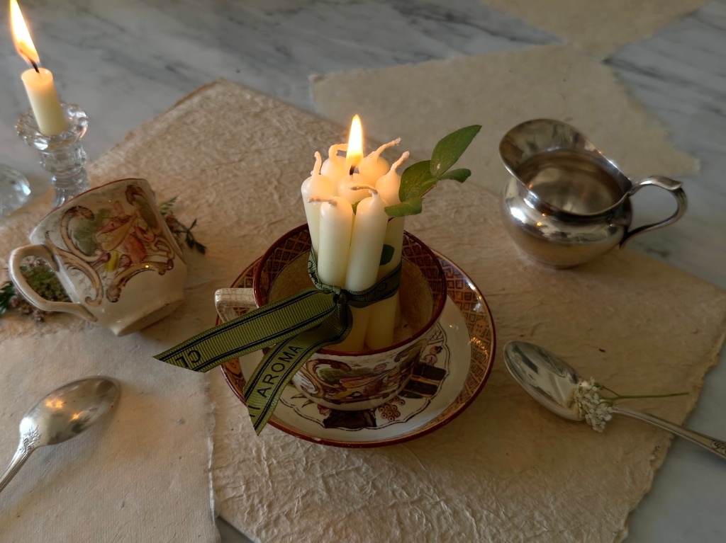 The larger Sarreguemines cup holding a bundle of candles