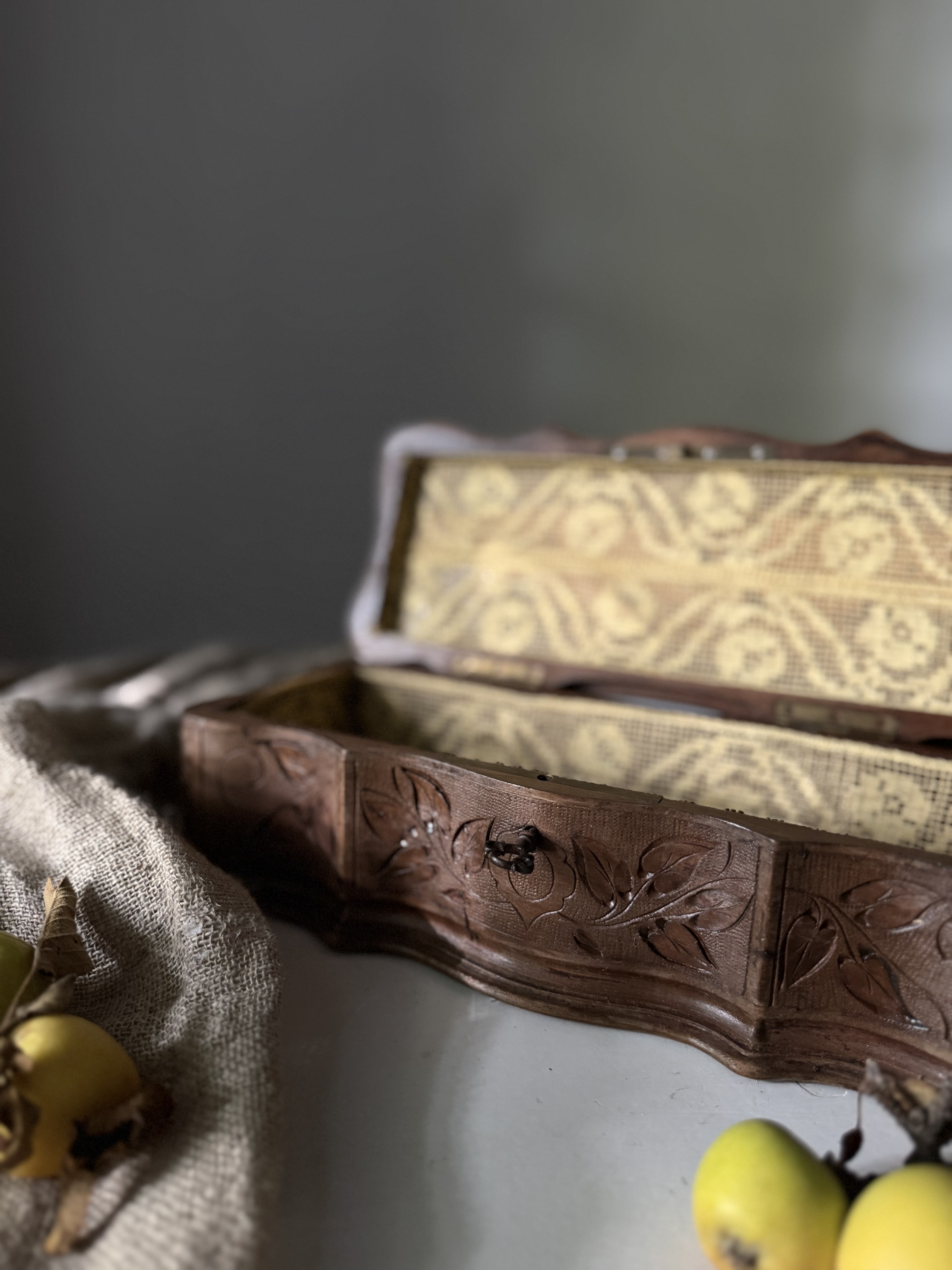 Open view of the carved box showing the lace-lined interior and velvet bottom