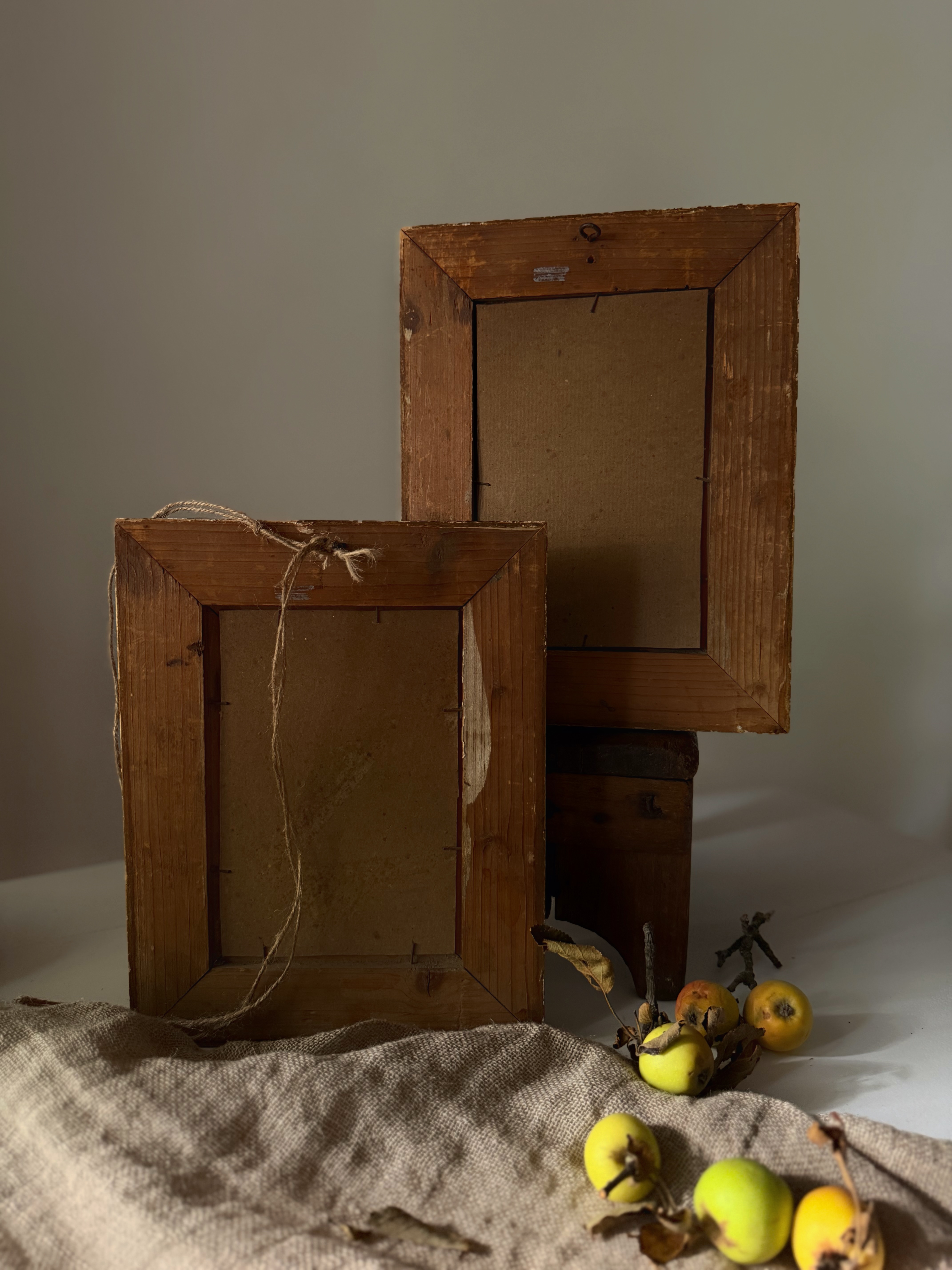 Reverse side of the antique paintings showing weathered wooden backs and twine